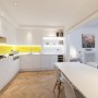 Kensington Basement | White kitchen with yellow splashbacks | Interior Designers