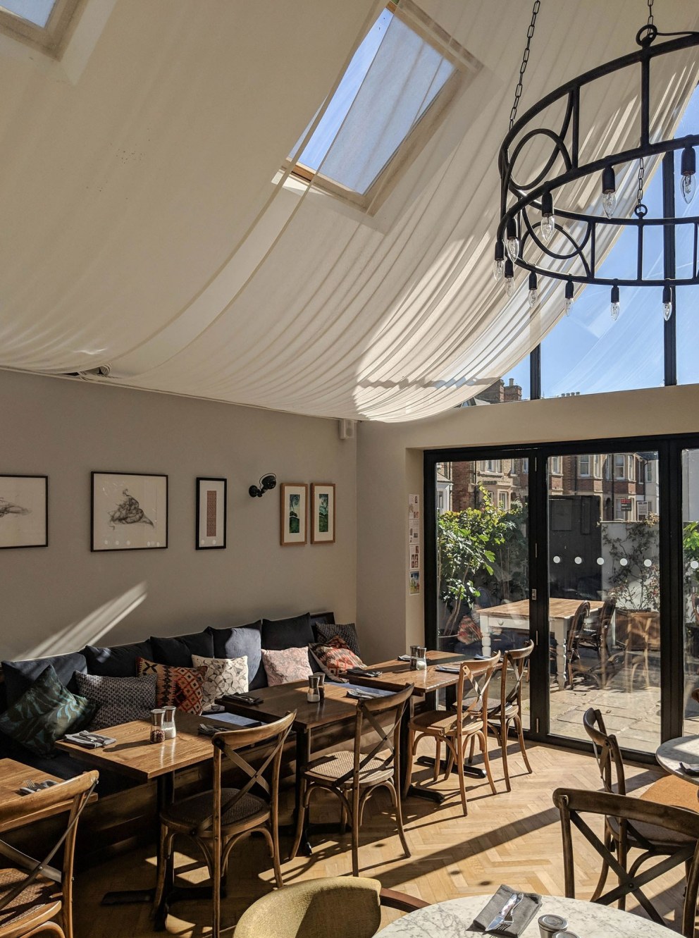 ThirtyEight, Summertown Oxford | Main dining room with bespoke linen ceiling sails, softening the view out onto the private courtyard | Interior Designers